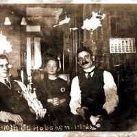 Sepia-toned photo of 2 men and a boy in parlor at 108 Tenth Street, Hoboken, January 1, 1923. 4-3/8" wide x ca. 3-5/16" high print.