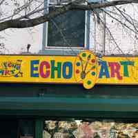 Color photo of hanging sign for Hoboken Furniture and wall sign for Echo Art, 157 First Street, Hoboken, Jan. 3 & 4, 2002.