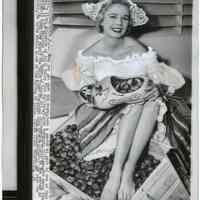 B+W photo of Rosemary Gilligan, 1955 National Tulip Queen, posed with tulip bulbs aboard the S.S. Westerdam, Holland America Line, Hoboken, Sept. 27, 1955.