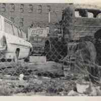 B+W photo of trash near fence belonging to Diamond Reo of Hudson County, 8th & Madison Sts., Hoboken, no date, ca. 1970-1975.