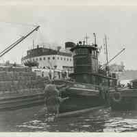 B+W photo of the tugboat Paterson moving an Erie Railroad barge to a pier, [Jersey City, N.J.], no date, ca. 1950.