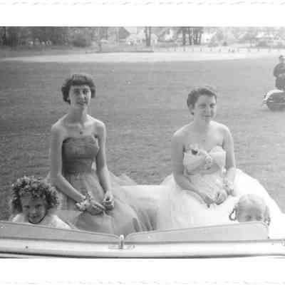 Two Tillicum Pageant princesses, Verene B and Esther Cedergren, sitting in back of car, with two children in front