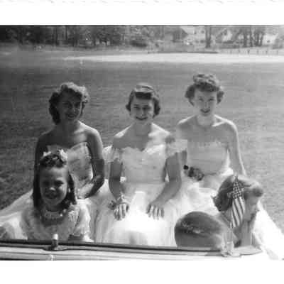 Three of the Tillicum pageant princesses sitting in back of convertible car, with three children in front.