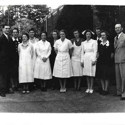 Nurses and staff posing in front of building with A. G. Hudtloff