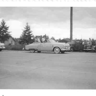 Five young women in cowboy hats riding in back of convertible with illegible sign on passenger door during Parkland Parade