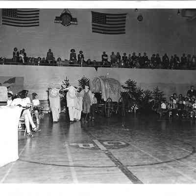 Skit of covered wagon with oxen costumes in the middle of assembly