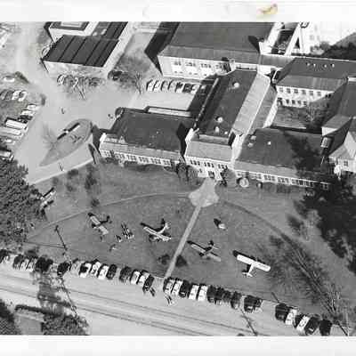Close up arial shot of the front of Clover Park High School with five planes parked on front lawn