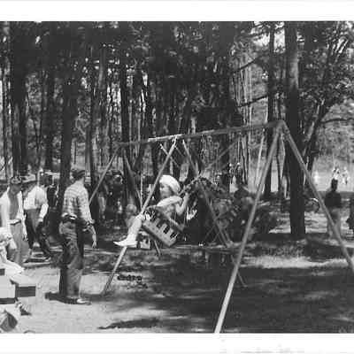 Families playing in park and swinging on swings, unidentified location