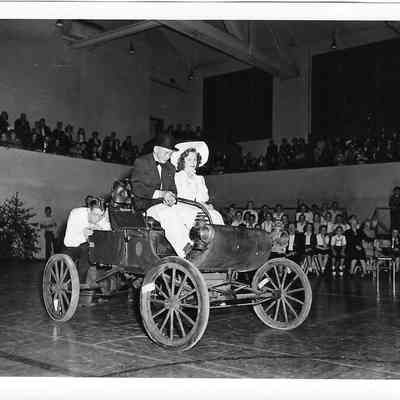 Driving a buggy in period costume through a Clover Park assembly