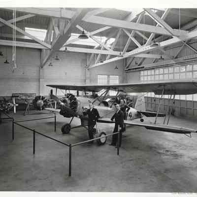 A. G. Hudtloff and three other men posing in and around an airplane in a hangar
