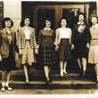 Six girls, hand-in-hand, stepping down from front steps of Clover Park Junior-Senior High