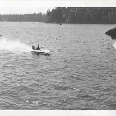 Boat pulling in lead nearing black checkered flag during boat race on American Lake