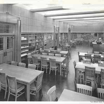 Library, empty tables and partially filled shelves