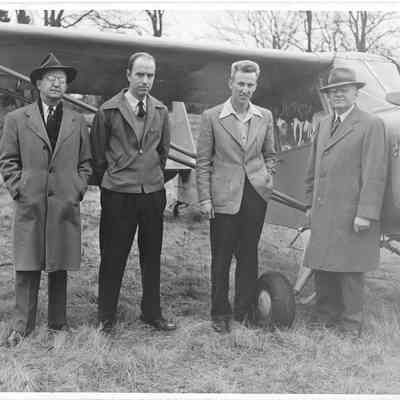 A. G. Hudtlof, Miner, Early Aynden, Jurall, and one other man posing to camera right of an airplane 1950