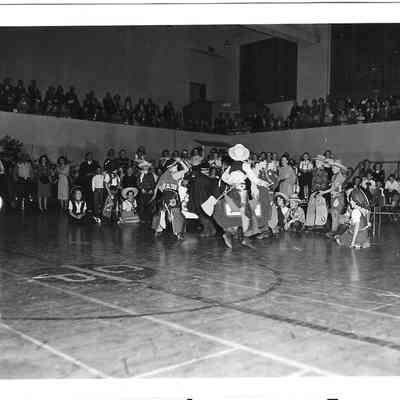 Children dressed as cowboys in middle of gym assembly