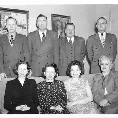 Four men and four women from the Navy School posing on and behind couch, May 1950