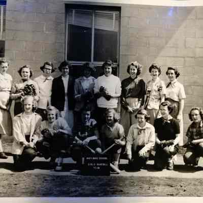 Navy Base School Girls Baseball posing outside building
