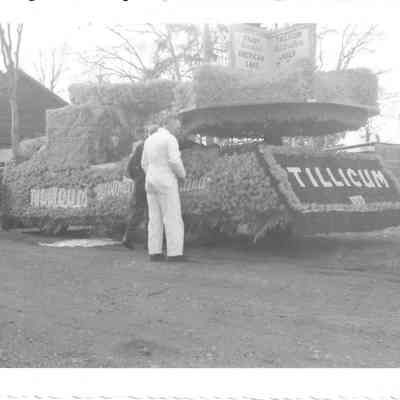 Two men inspecting a flower-covered float from the Tillicum 4th of July Parade