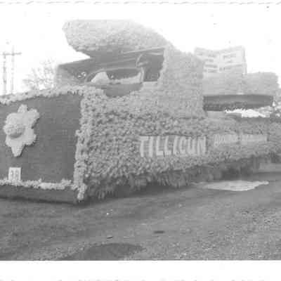 3/4 view of the Front view of the American Lake Improvement Club/Tillicum float for Daffodil Parade, car in background
