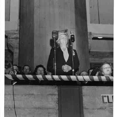 Pearl A. Wanamaker, State Supt. Of Public Instruction, in front of two microphones at Clover Park, small crowd behind him