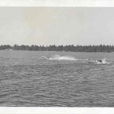 Several boats turning during a boat race on American Lake, tree covered shore behind