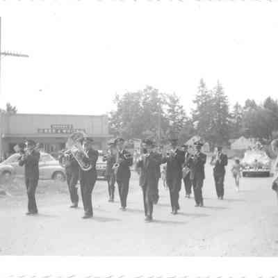 Members of Union Band marching in parage in front of the Johnson's Red & White store