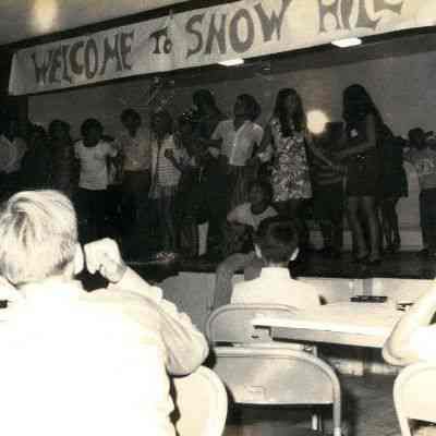 Photograph with “Welcome to Snow Hill” banner and unidentified people