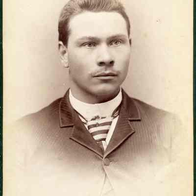 Portrait photo of a young man in a suit with a striped tie. Photographed by LaRoche & Co at 606 Second St. Seattle WA.: 2024.III.I.3.b.005