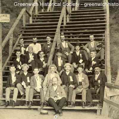 Men with Honorary Badges Seated on Stairs to Swimming Dock