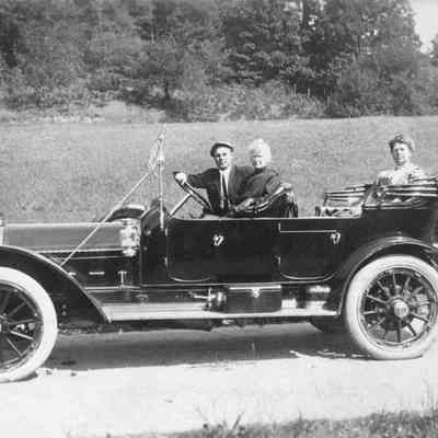 People in an early model car
