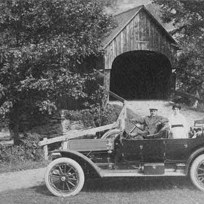 Car in front of covered bridge 6-0360