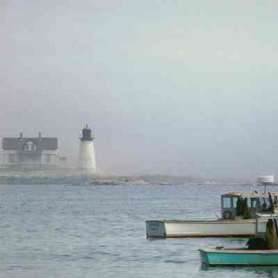 Prospect Harbor Lighthouse and Keeper's Cottage with lobster boats in the foreground.