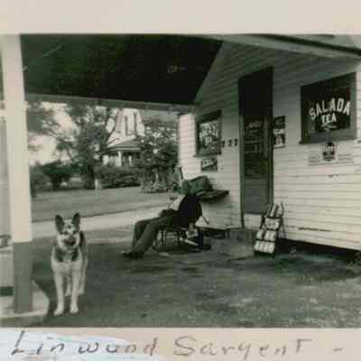 Linwood Sargent and his dog in front of his Store and Gas Station, West Gouldsboro, Maine.