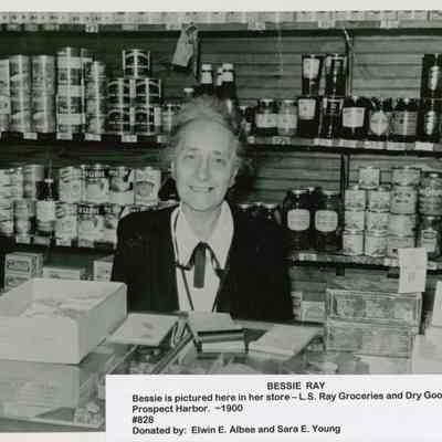Bessie Ray behind the counter of L. S. Ray Groceries and Dry Goods Store in Prospect Harbor.