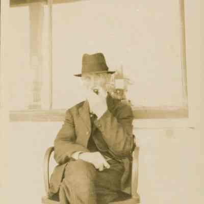 Man in chair in front of a store.