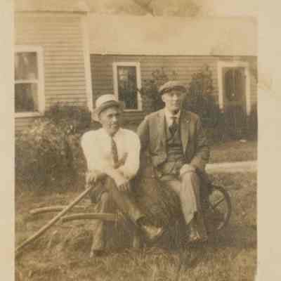 Two men sitting on a hay bale