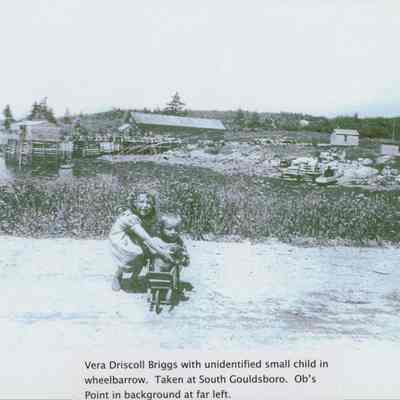 Vera Driscoll Briggs with a child in a wheelbarrow.