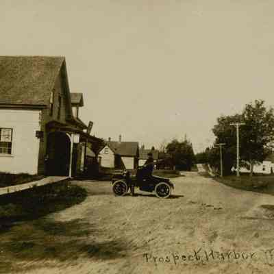 Main Street, Prospect Harbor, ME. Cole's Store in the foreground and n automobile in the street.