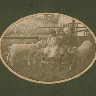 Blanche Marie Kingsley and Alpheus Hardy Kingsley playing with two white sheep.