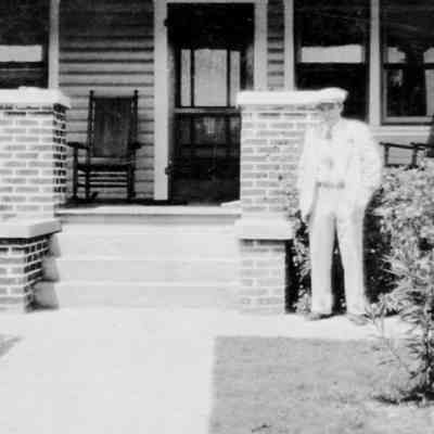 Sam Barket in fron of house, 1928.