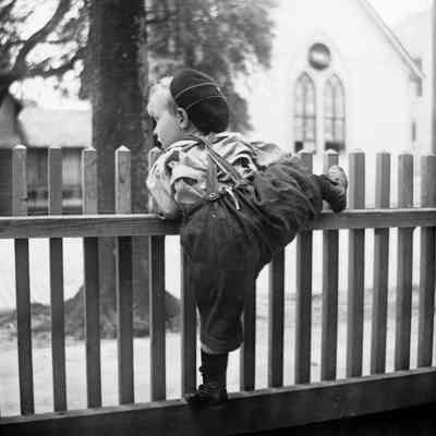 Leah Mary Cox photograph of a young boy climbing a fence