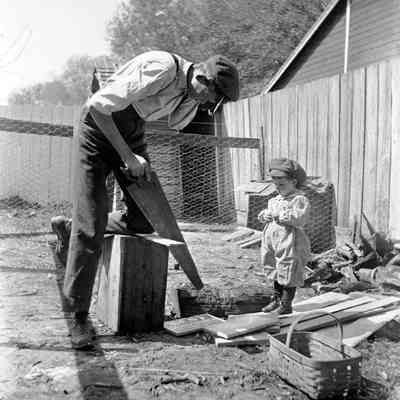 Leah Mary Cox photograph of a man sawing while a young boy watches
