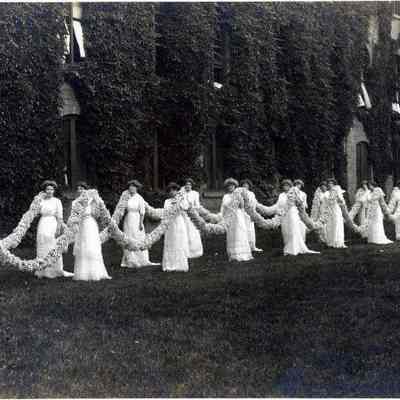 Vassar graduates with floral garland in floor-length gowns, 1902