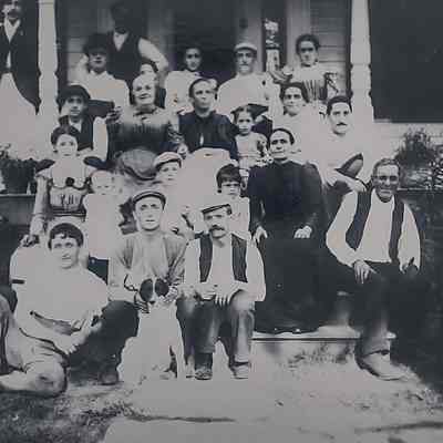 Large family group photo of the Retaliate family and their dog outside their farm house.