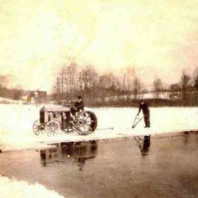 John Storms driving a tractor on Ackerman Pond