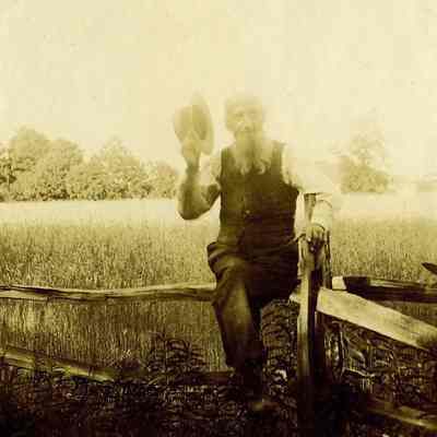 Man tipping hat with fields in background