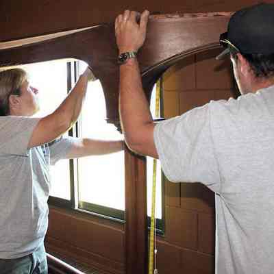 William Graves, Jody and Jeffrey Paine of Graves Builders attach the mahogany arches to the balustrade