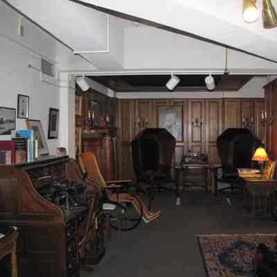 The original Vail Museum overview photo showing many items: Items include the hooded chairs, a roll-top desk and panelling from Vail Mansion