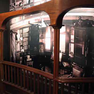 Side view of Vail Mansion library mural with original mezzanine balustrade: Illuminated museum display, 3/4 side view. Photo of display by Michael Thurston