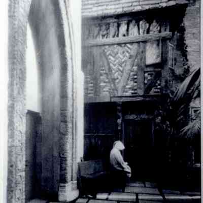 1930 Hammond in monk's robe on Courtyard bench
